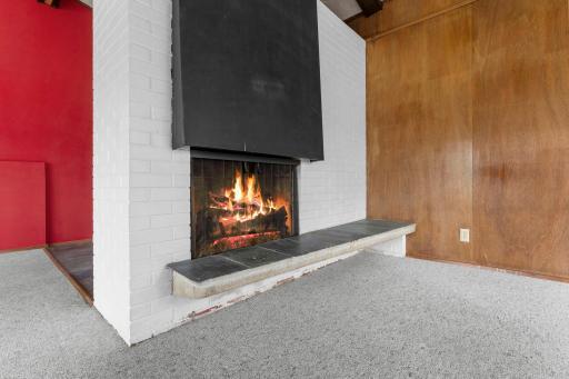 Cozy, wood burning fireplace accented by white brick.