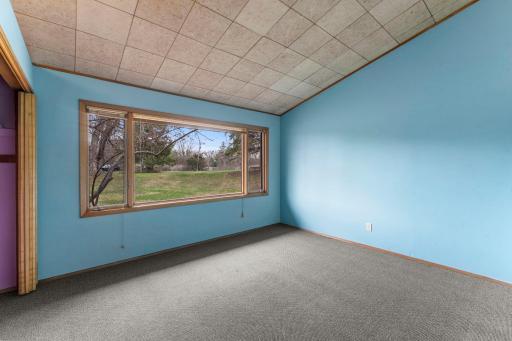 Primary bedroom with large window. Vaulted ceilings.