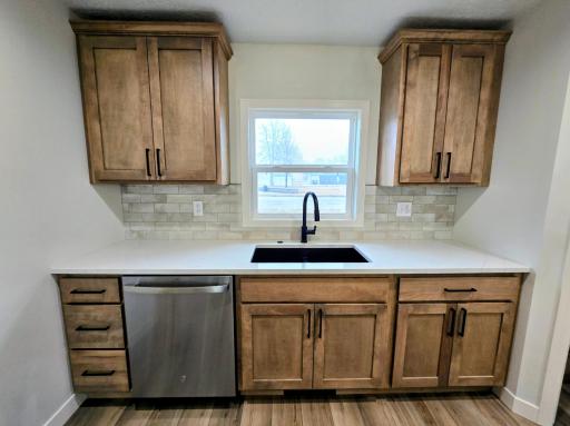 Attractive maple cabinets, farmhouse sink, stainless steel dishwasher