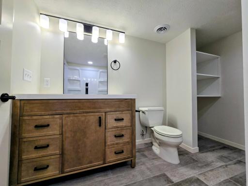Basement full bath. Attractive vanity-shelving for towels