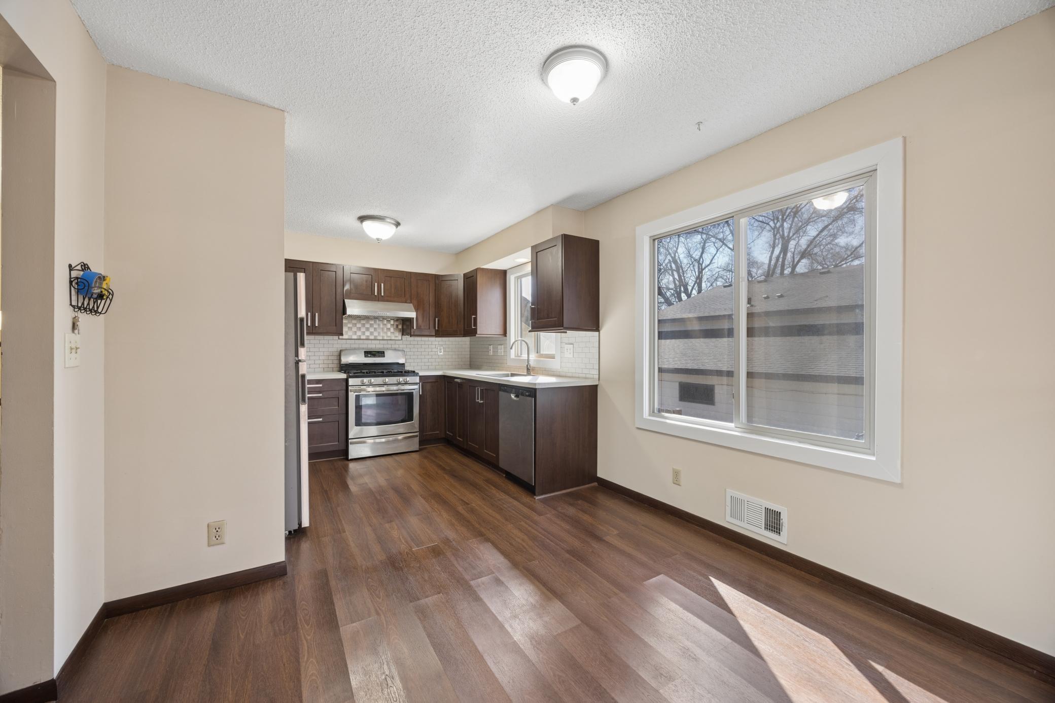 eat-in kitchen with stainless steel appliances, tile backsplash, and rich-toned cabinetry