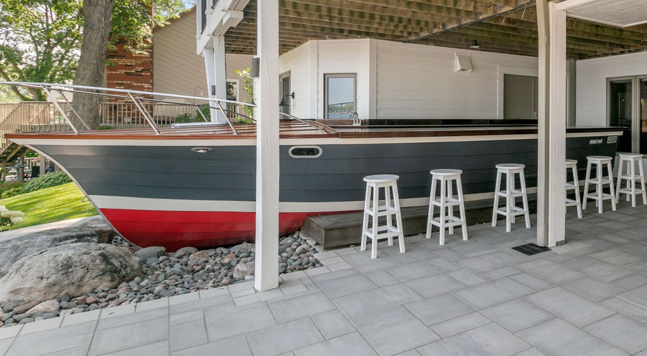 Beautiful landscaping was completely freshened up recently and this focal point antique boat was added as an outdoor bar space. Spaces flow easily from entertaining inside to out!