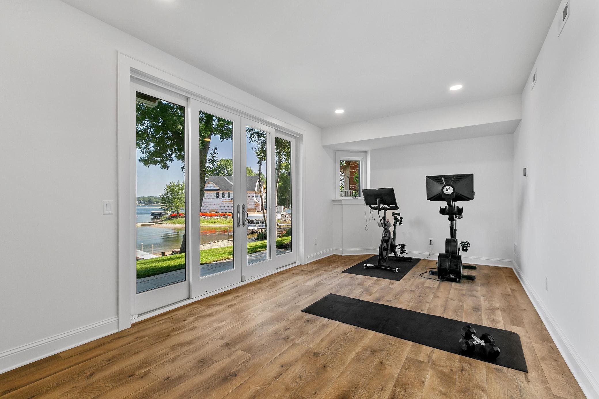 Dedicated exercise space where you can bring the outside in with more wide patio doors and expansive lake views! You have no excuse to skip your workout here!