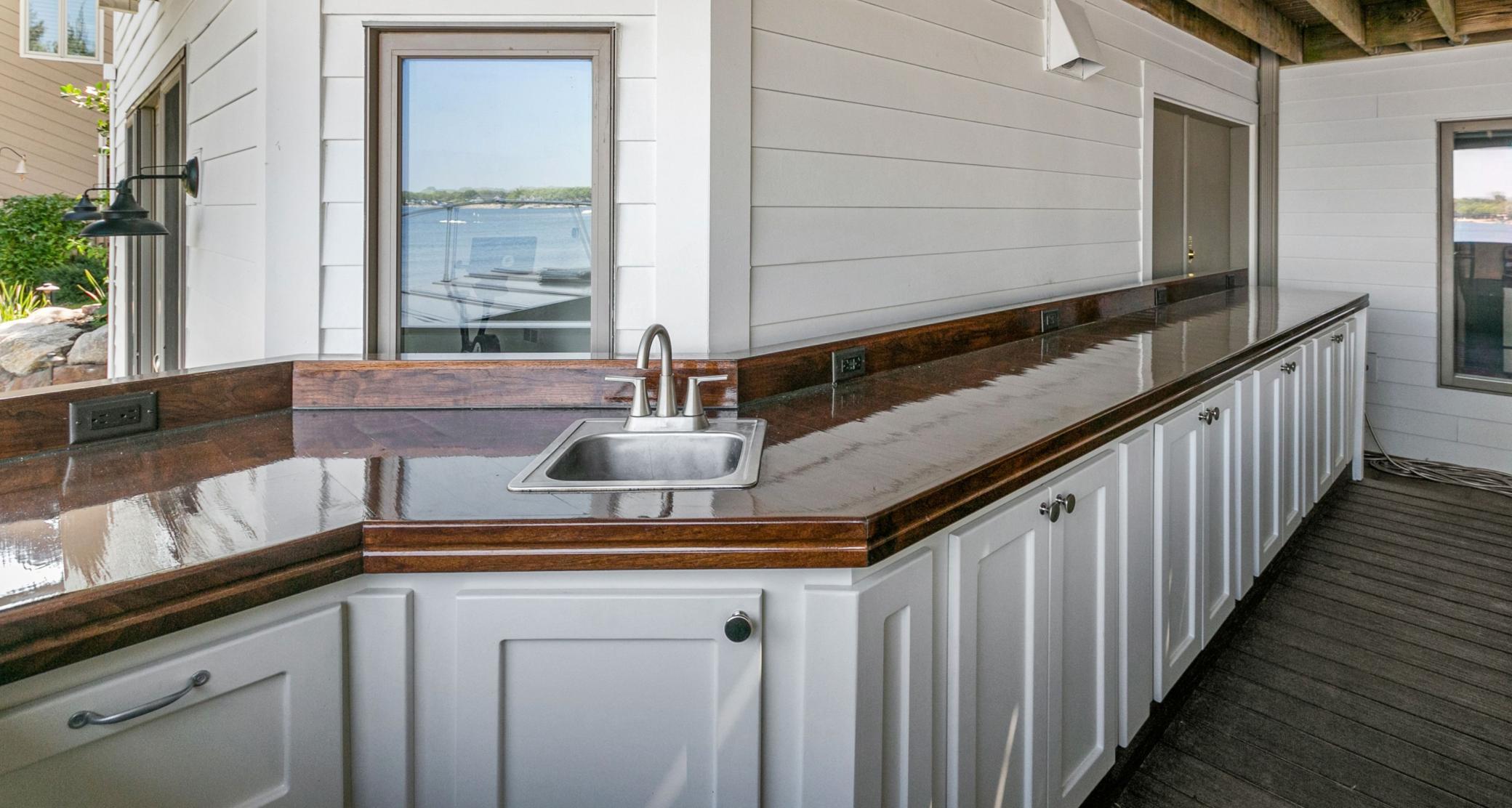 Perfectly shaded after a long day in the sun, this lower level entertaining space is so welcoming! This bar provides storage for everything you need from the cutlery and glasses to the citronella candles, flashlights and blankets.