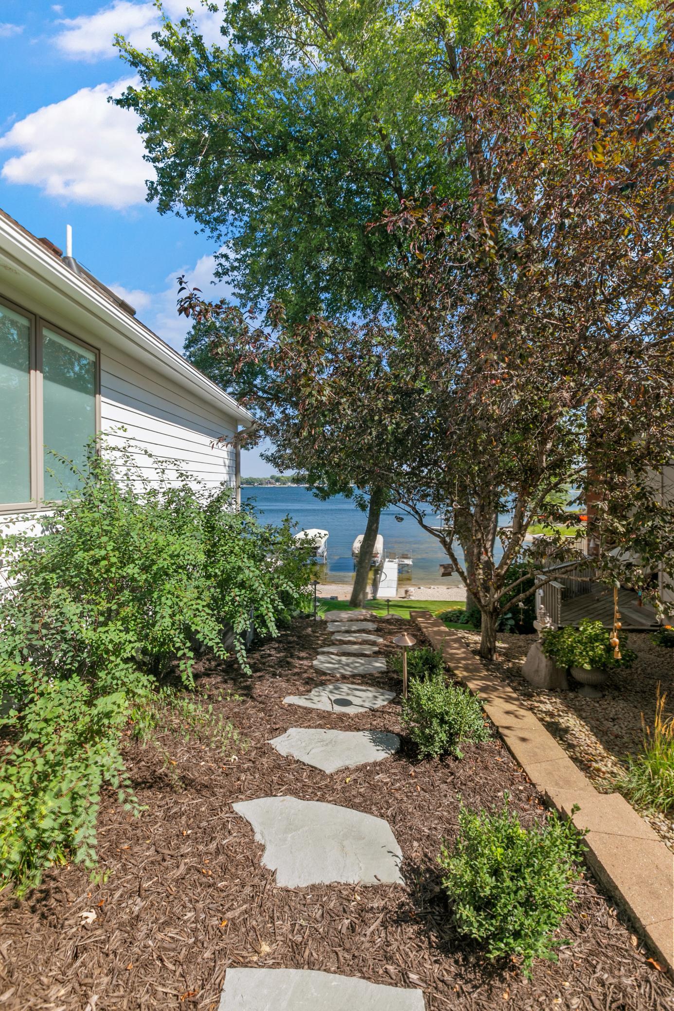 Charming stone pathway along the side of the home leading toward beautiful views of Prior Lake.