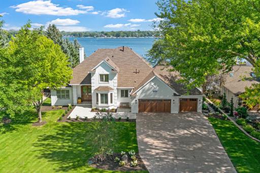 A full view of the home showcasing the beautiful landscaping, spacious front yard, and 3-car garage.
