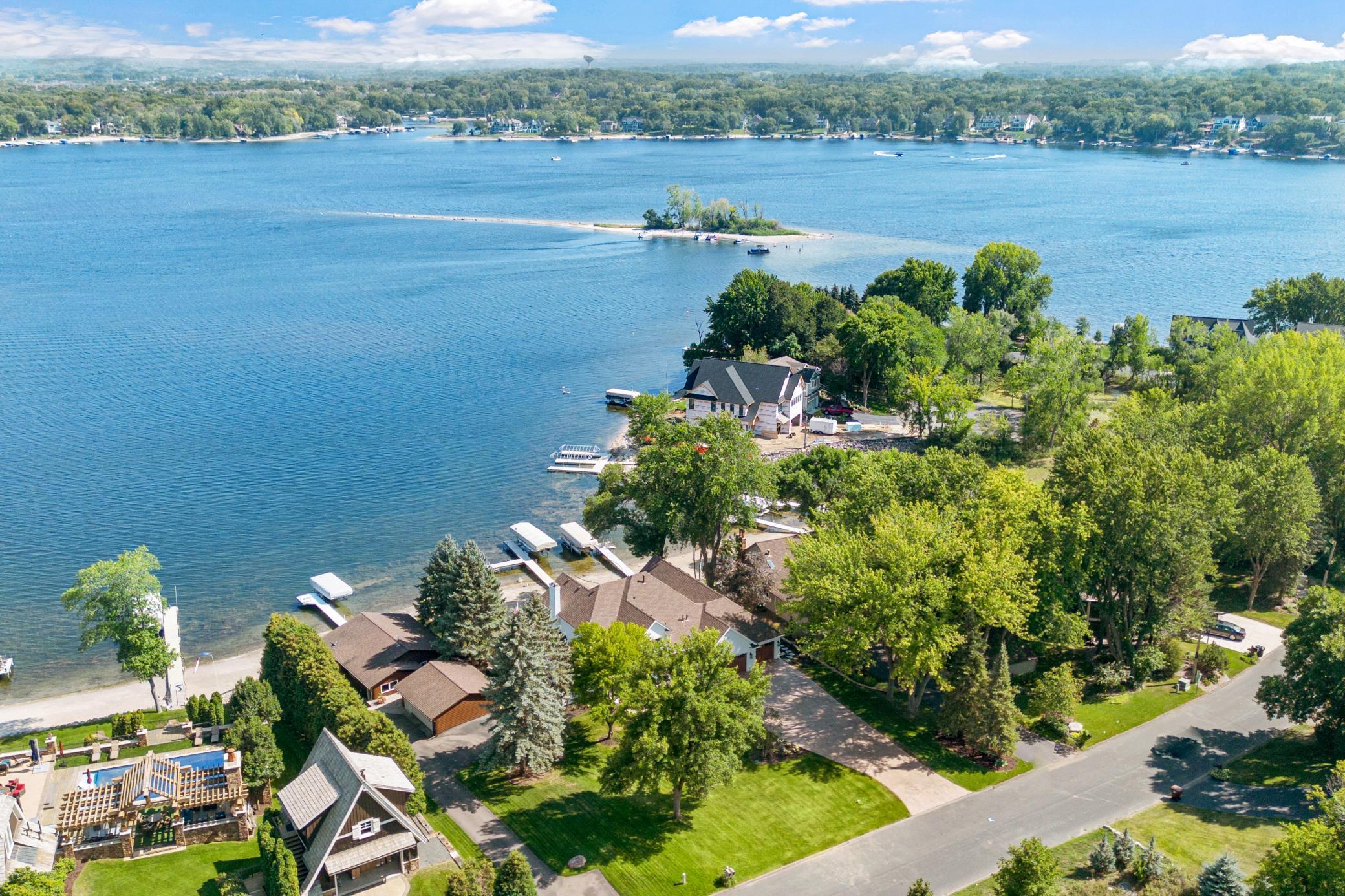 Sweeping views of the lake, mature trees, and beautiful neighboring lakefront homes along the shoreline.