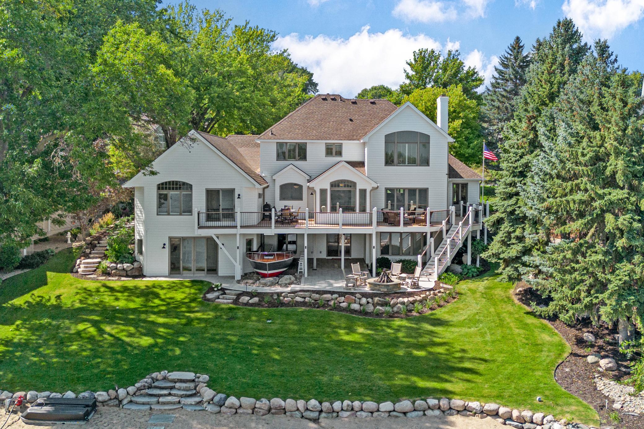 The back of the home is just as stunning, with beautiful architecture and outdoor spaces designed to enjoy the lake setting.