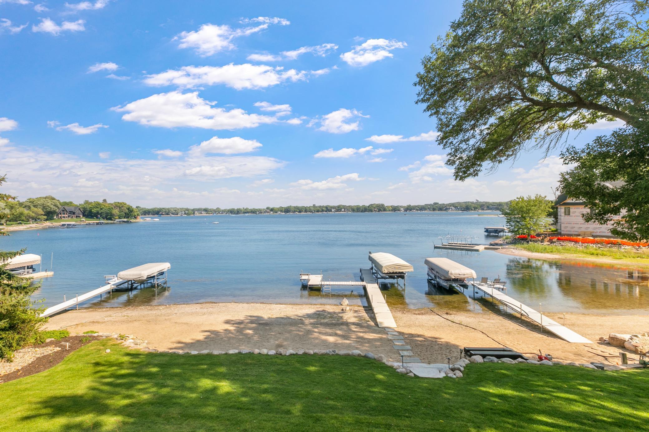 Beautiful sandy shoreline with a private dock and boat lift, ready for days spent enjoying the lake.