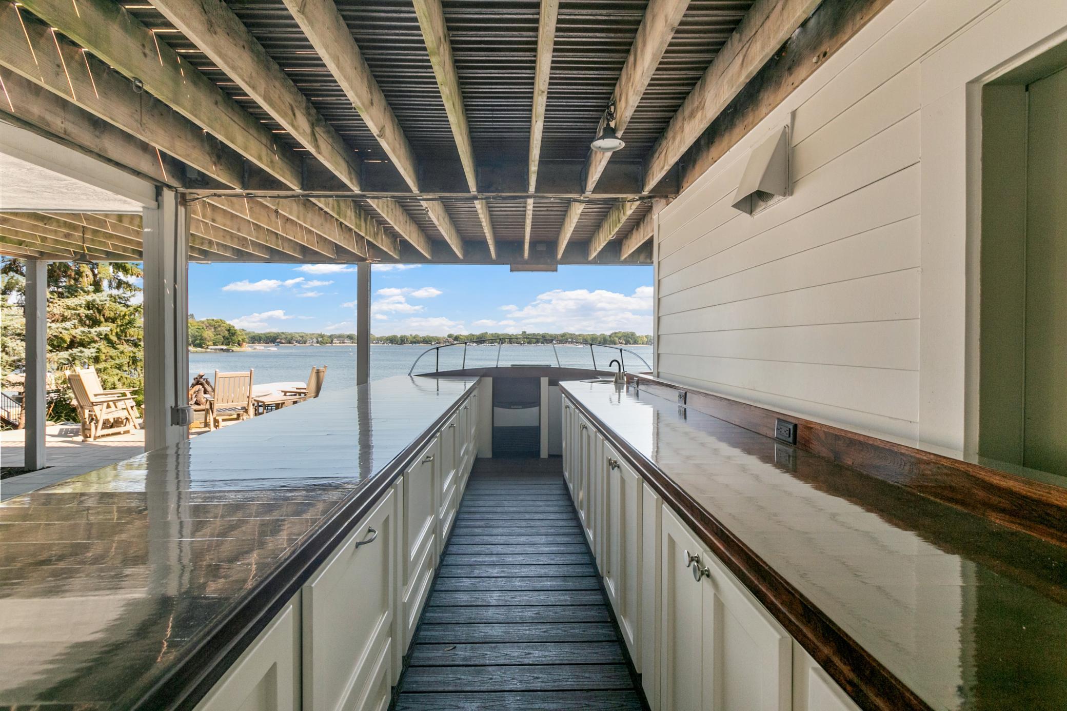 One-of-a-kind custom boat bar creating an unforgettable outdoor space for hosting friends and family by the lake.