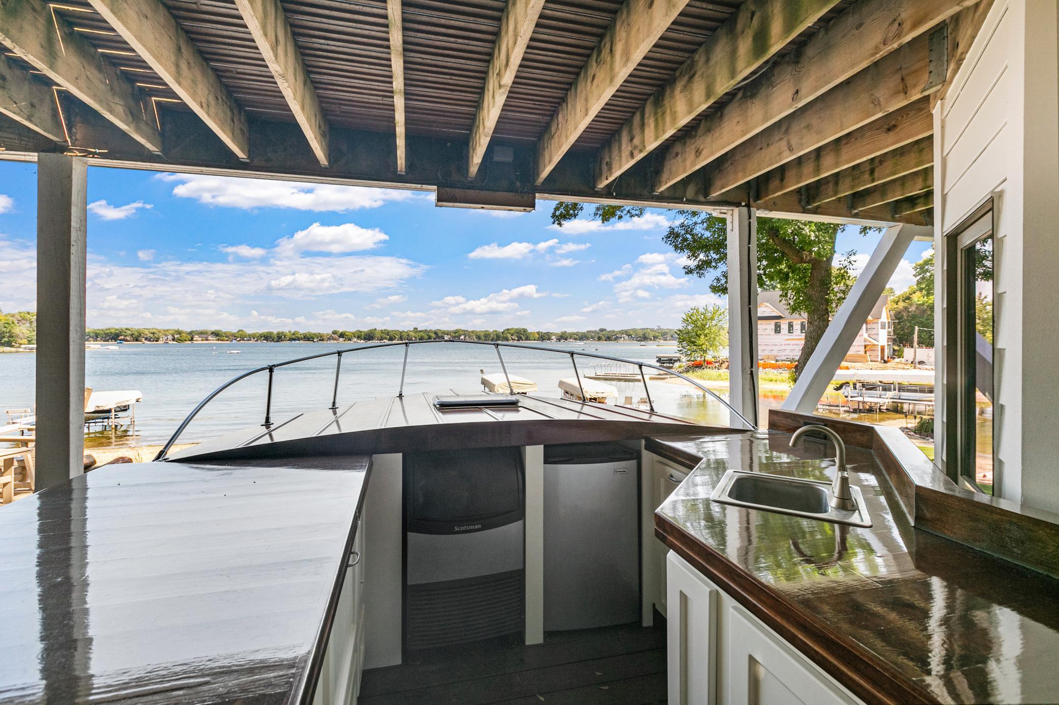 One-of-a-kind custom boat bar creating an unforgettable outdoor space for hosting friends and family by the lake.
