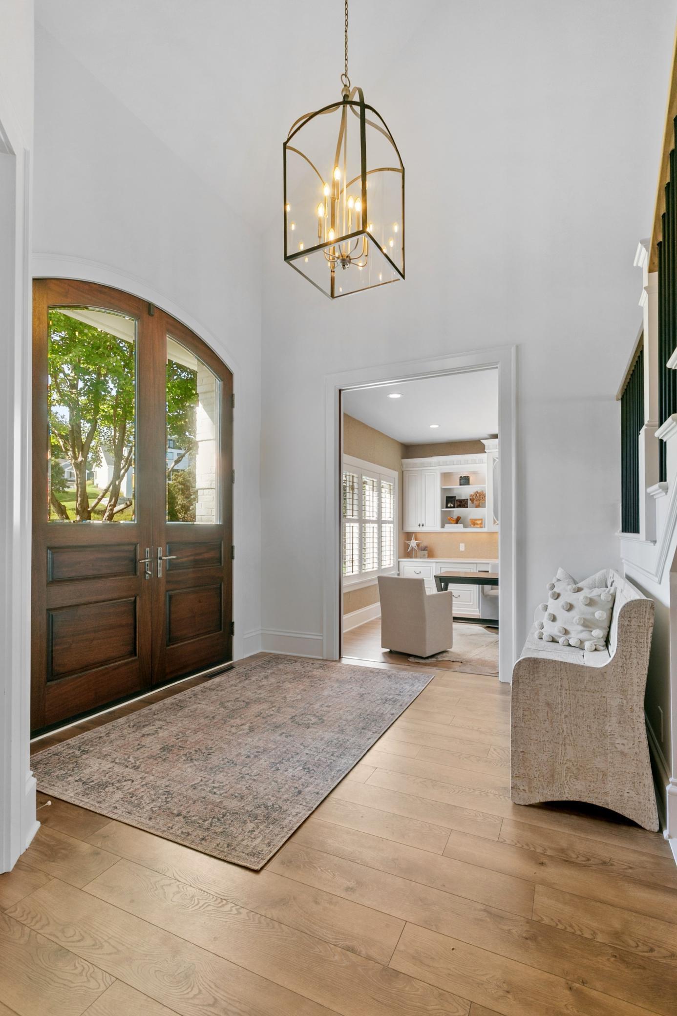A welcoming entryway featuring beautiful double wood doors and a warm first impression as you step inside.