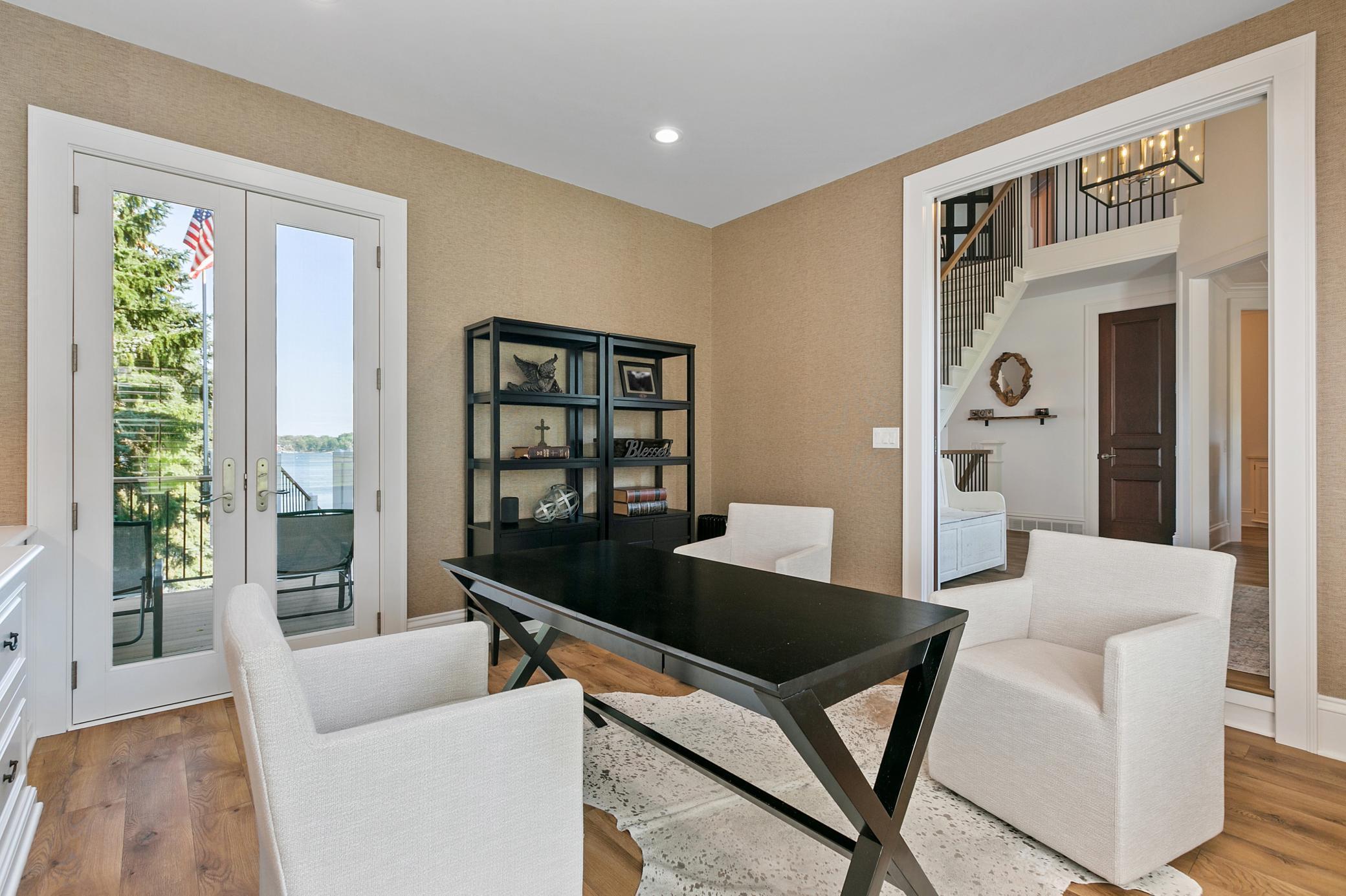 Main-level office with double glass doors opening to the deck, offering beautiful lake views while you work.