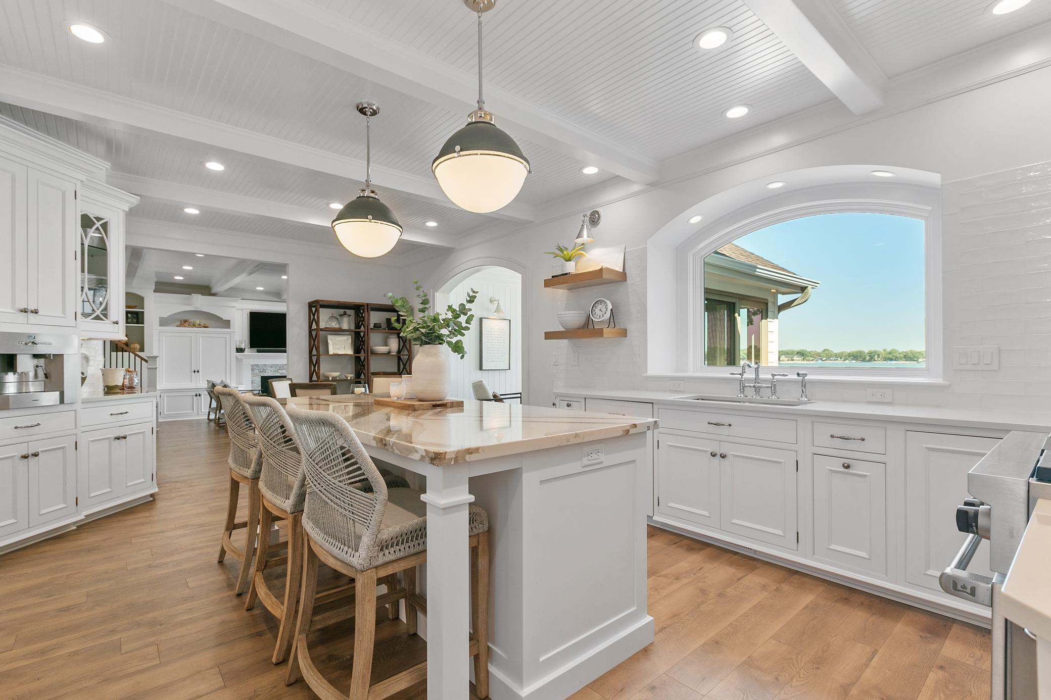 Spacious and well-equipped kitchen with a beautiful island for seating and stunning lake views just beyond the windows.