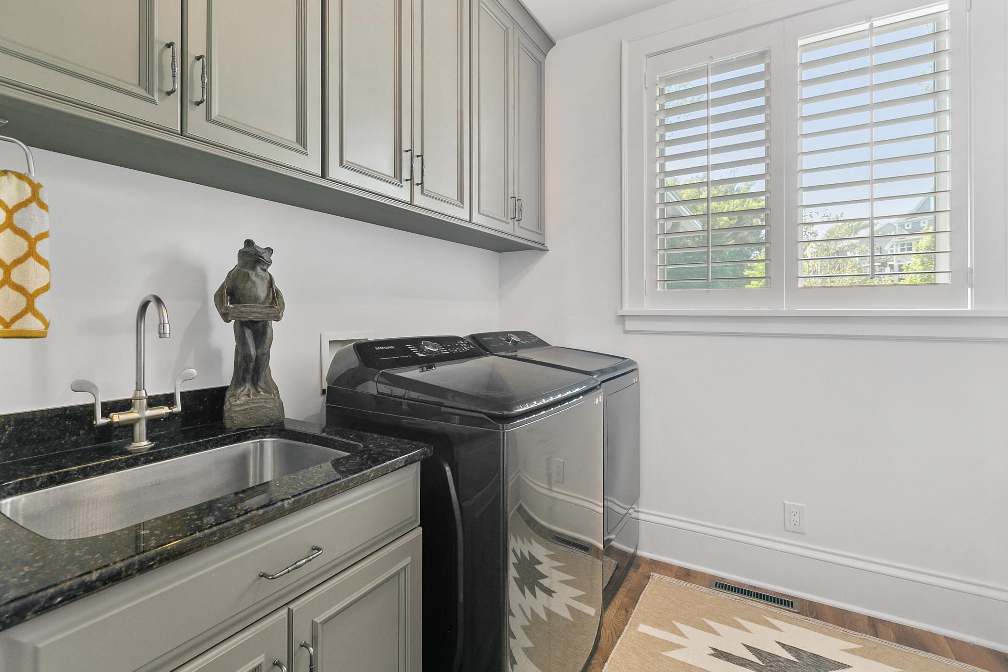 Spacious laundry room with a utility sink, abundant cabinetry, and plenty of storage to keep everything organized.