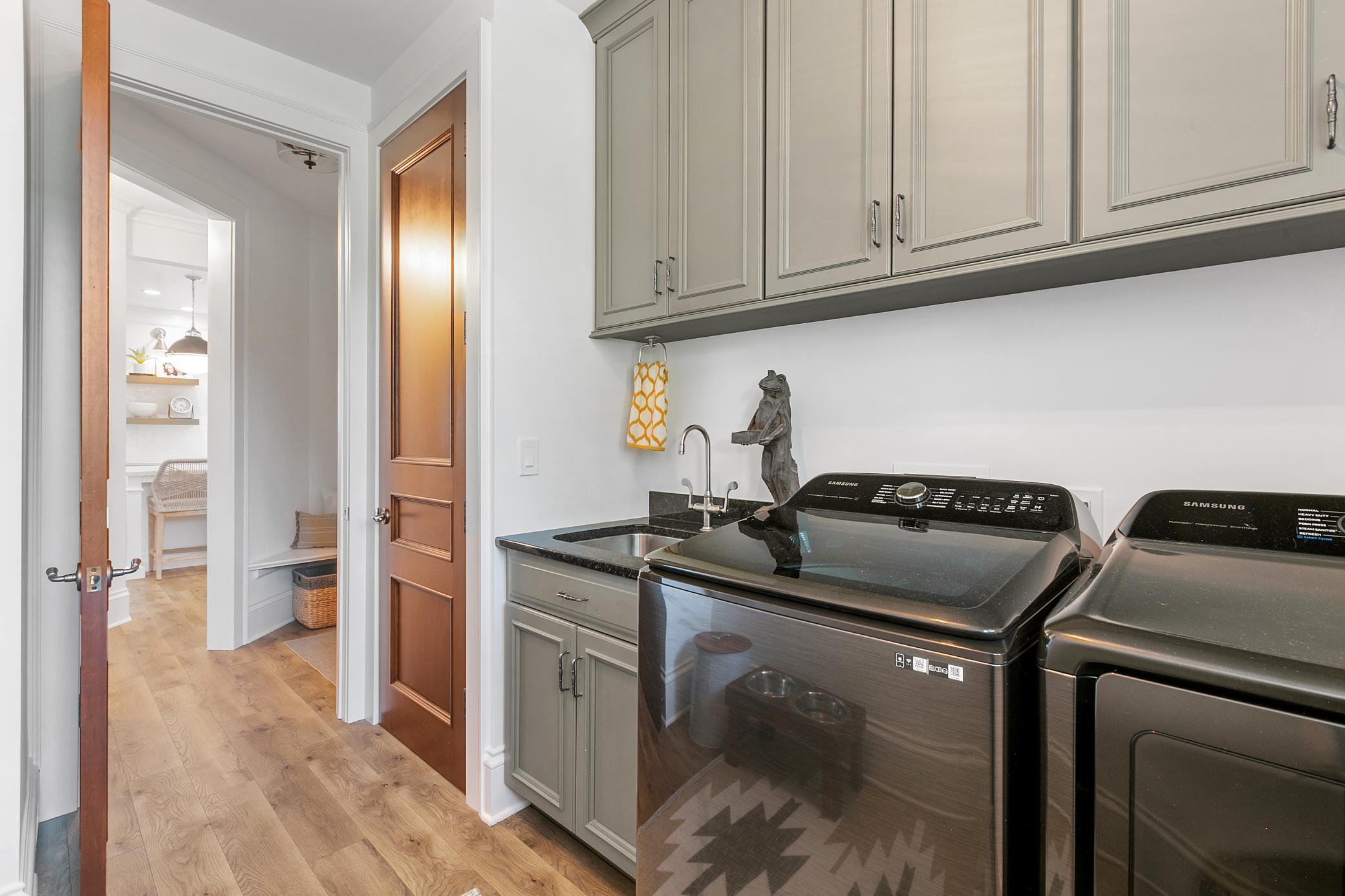 Spacious laundry room with a utility sink, abundant cabinetry, and plenty of storage to keep everything organized.