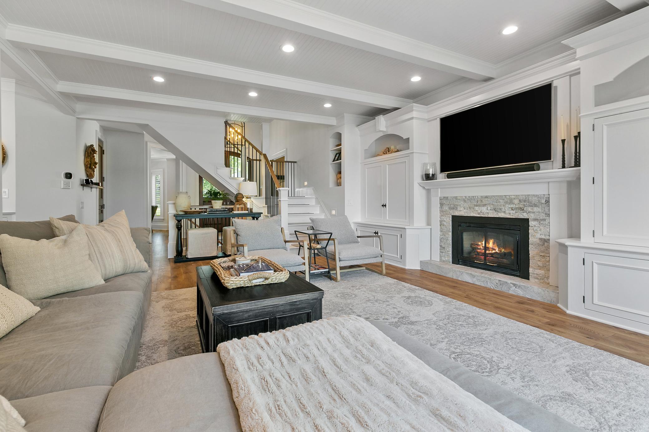 Cozy main level living room anchored by a beautiful fireplace, creating a warm and inviting space to relax.