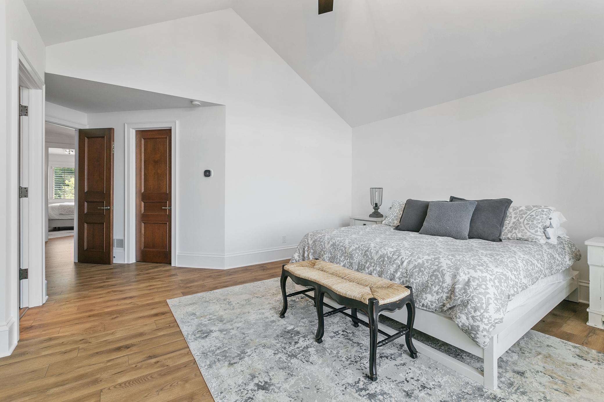 The upper level primary bedroom has a large walk in closet, huge window and vaulted ceiling.