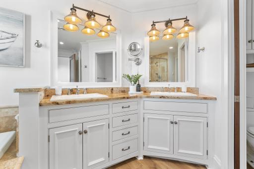 Spacious and elegant bathroom featuring double sinks, a soaking tub, and a separate shower.