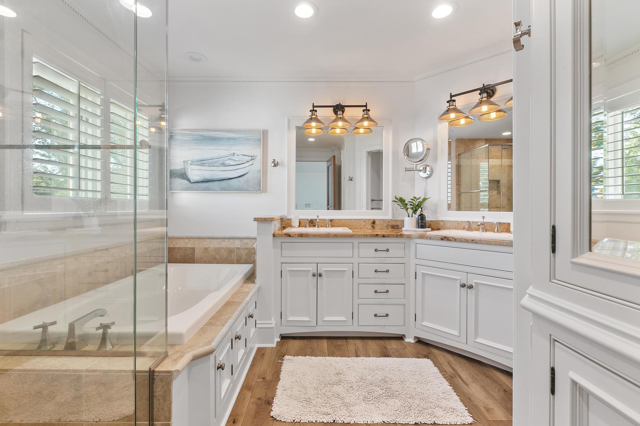 Spacious and elegant bathroom featuring double sinks, a soaking tub, and a separate shower.