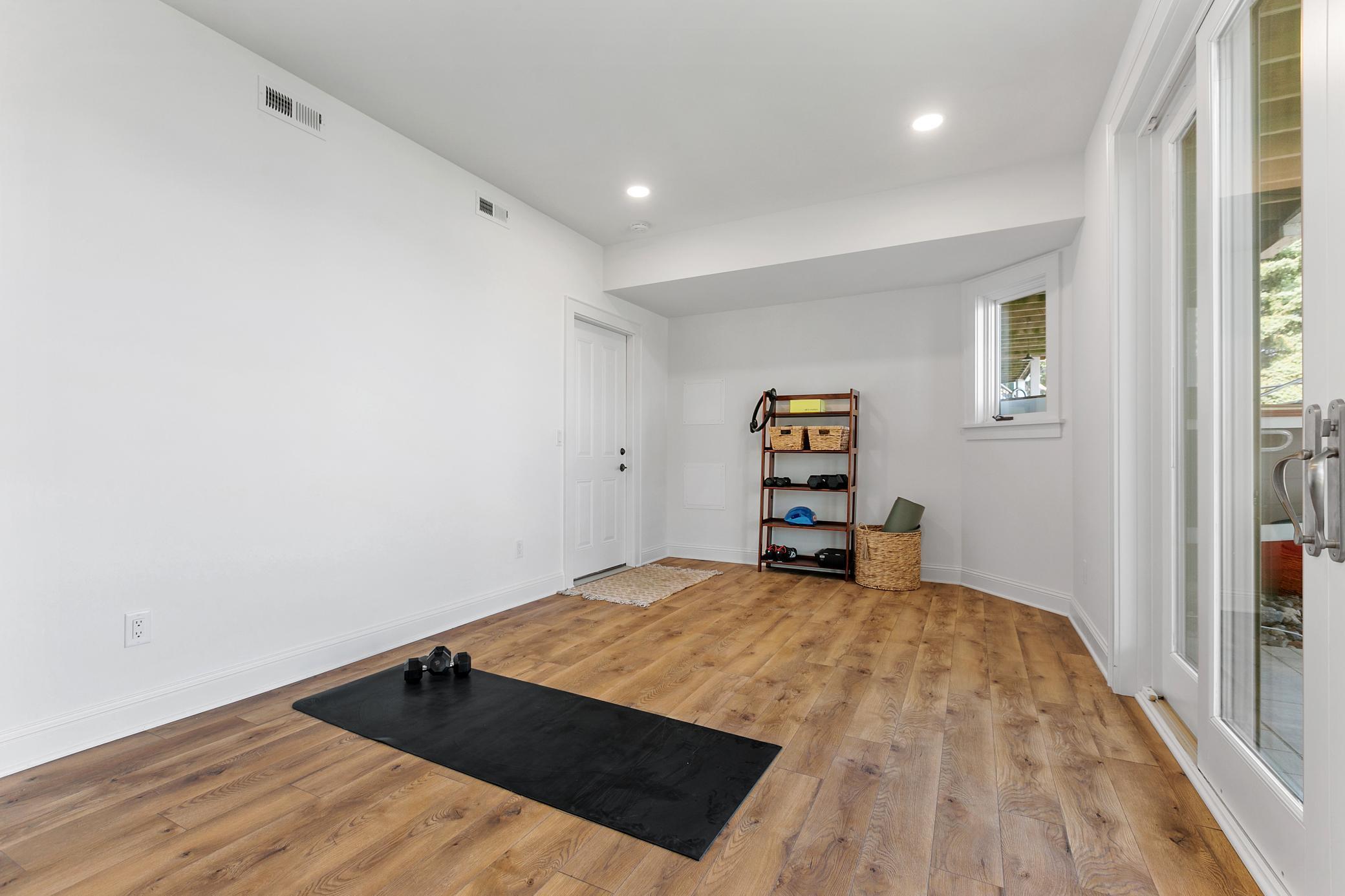 A bright, dedicated workout space with wide patio doors and beautiful lake views. Staying active is a lot easier when this is your view.
