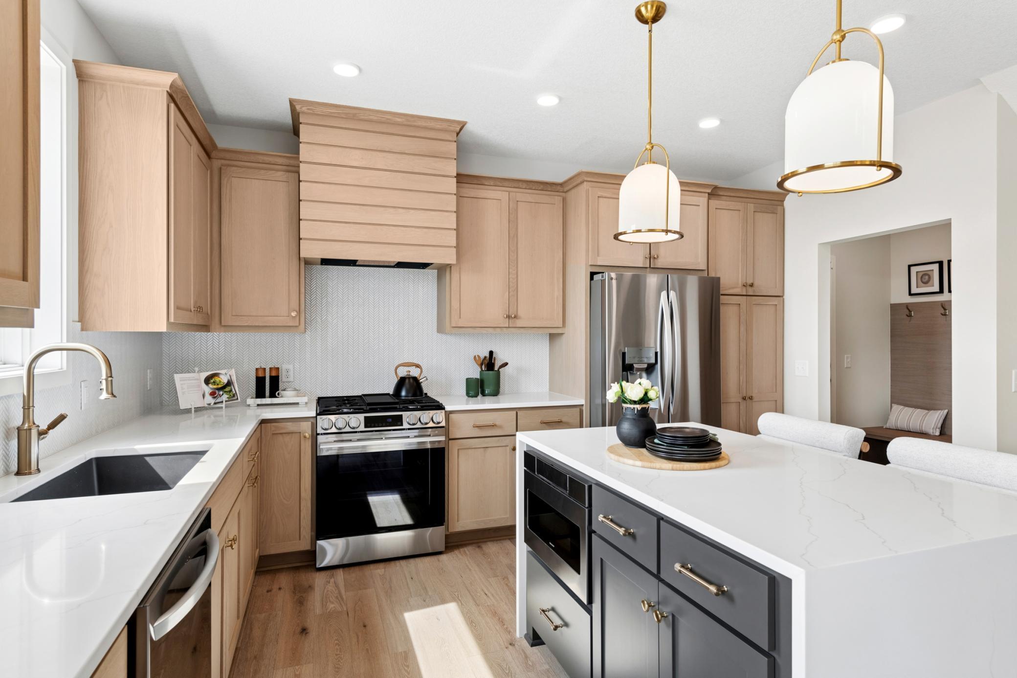 Striking quartz island with a sleek waterfall edge creates a stunning focal point. *Photos are of like home and may not depict actual home plan. Configurations, features, materials and finishes may contain options that are not included in the price.