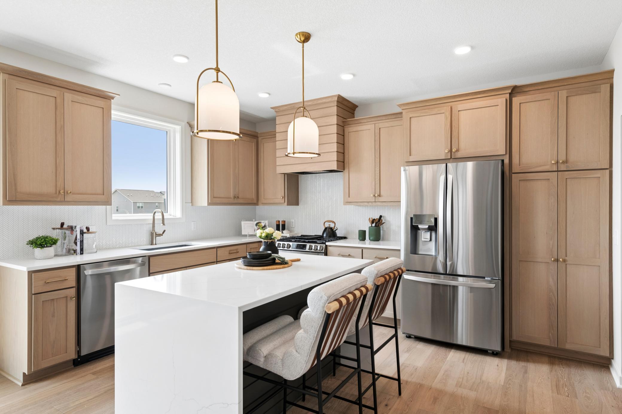 Striking quartz island with a sleek waterfall edge creates a stunning focal point. *Photos are of like home and may not depict actual home plan. Configurations, features, materials and finishes may contain options that are not included in the price.