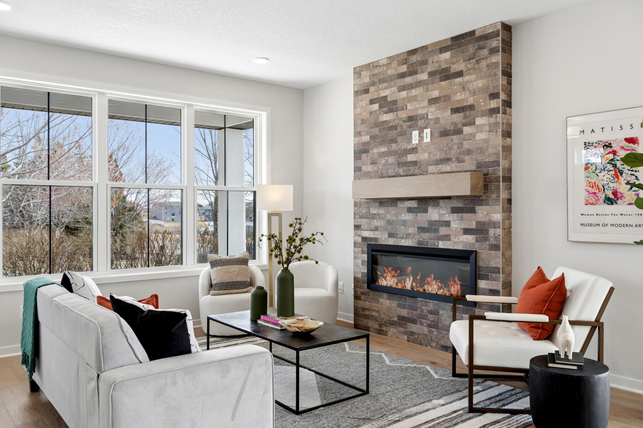 Sleek electric fireplace with modern tiled surround creates a stylish focal point. *Photos are of like home and may not depict actual home plan. Configurations, features, materials and finishes may contain options that are not included in the price.