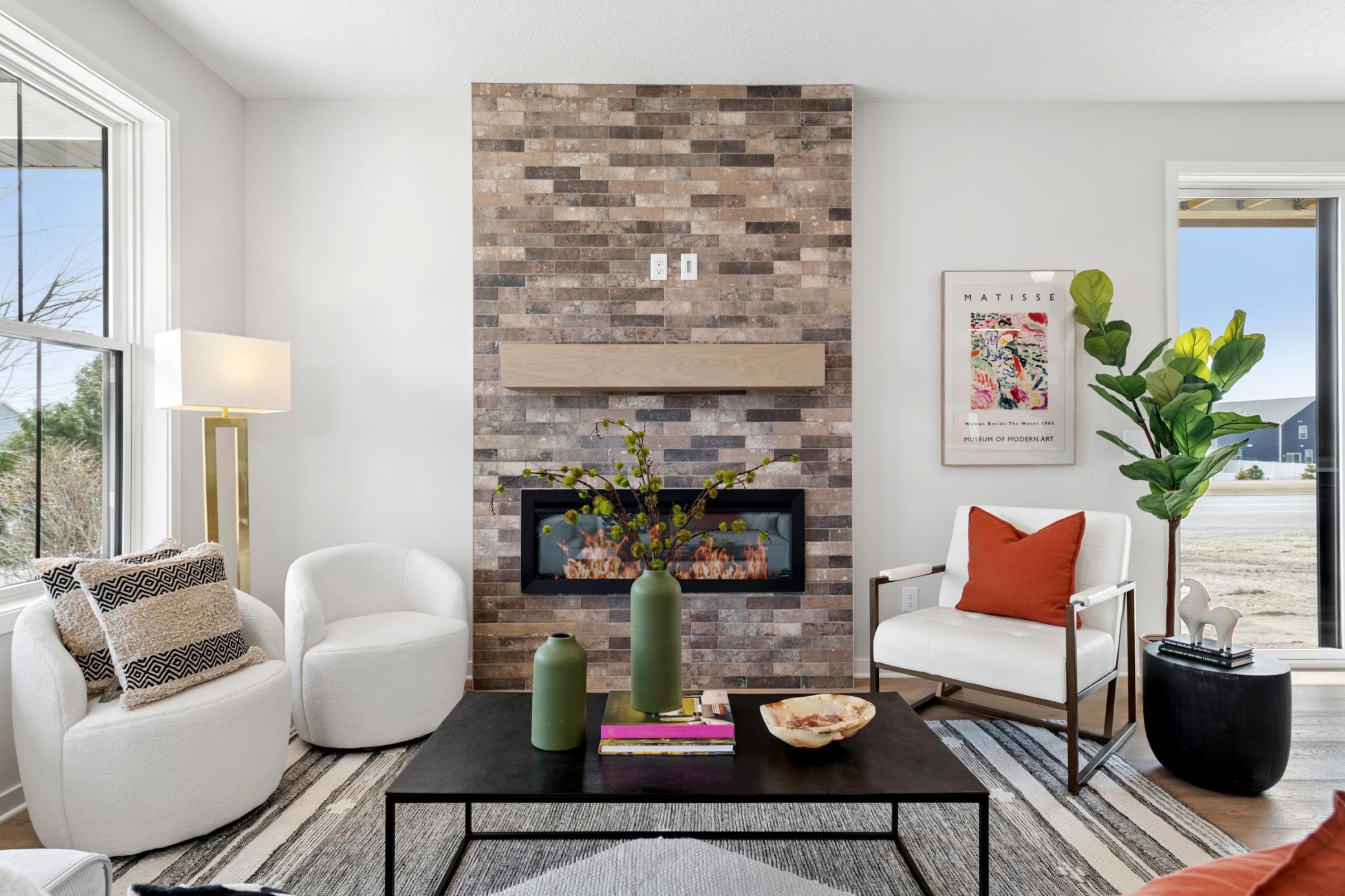 Sleek electric fireplace with modern tiled surround creates a stylish focal point. *Photos are of like home and may not depict actual home plan. Configurations, features, materials and finishes may contain options that are not included in the price.