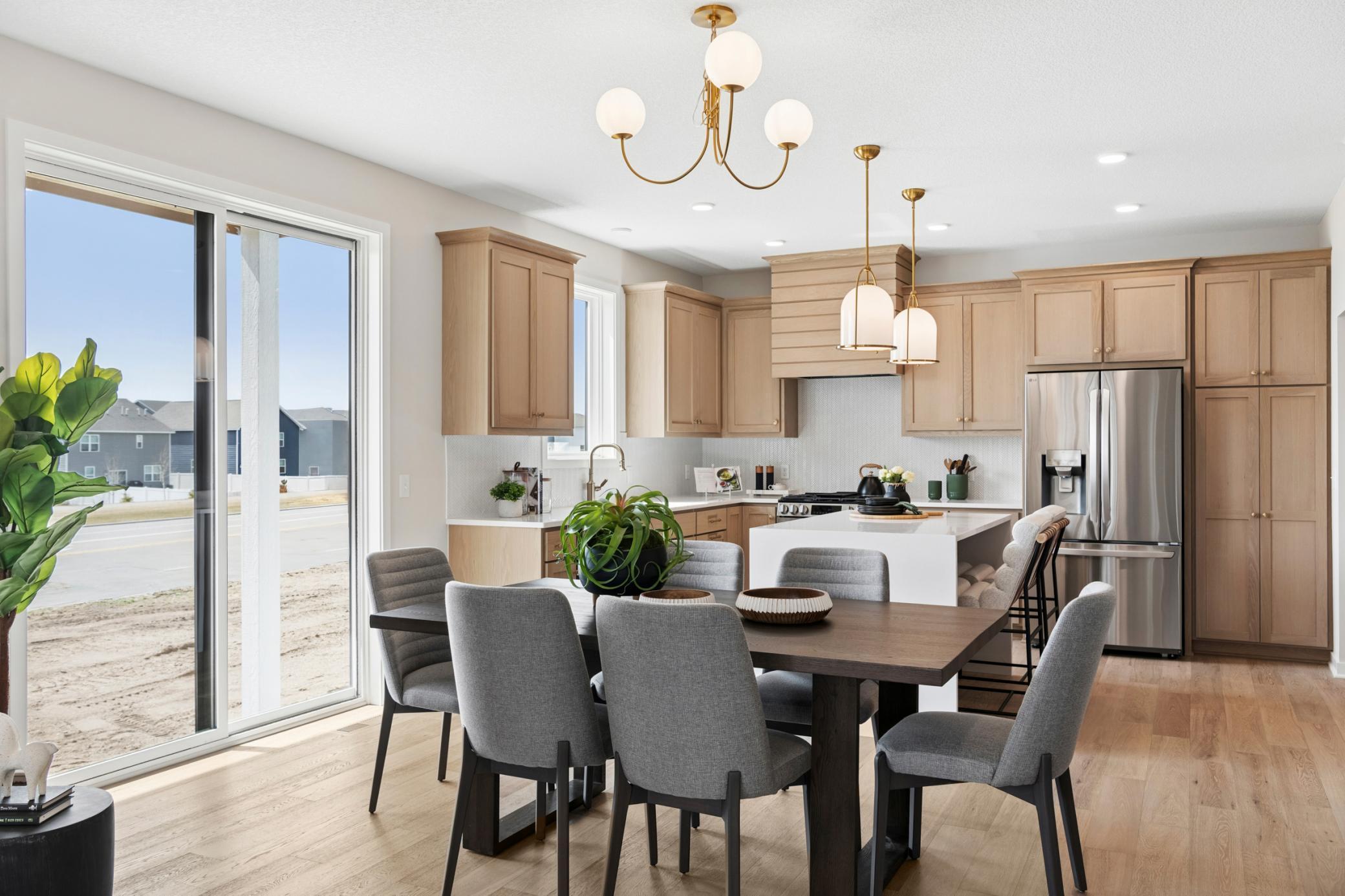 Modern kitchen filled w/natural light from expansive windows & a sliding glass door *Photos are of like home and may not depict actual home plan. Configurations, features, materials and finishes may contain options that are not included in the price.