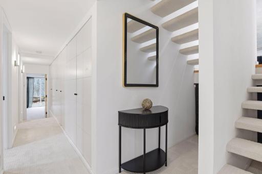 Step down into the home’s second lower-level wing, offering two Bedrooms, a full Bathroom, Laundry, and generous additional storage.