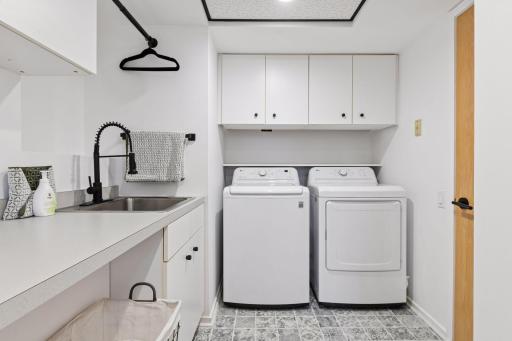The Laundry Room combines style and function with designer tile, extensive cabinetry, a generous folding counter, and a convenient laundry sink.