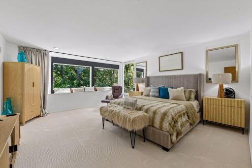 A peaceful and inviting Primary Bedroom offers a wonderful place to unwind, with a built-in window bench providing a cozy spot to sit and enjoy the tranquil surroundings.