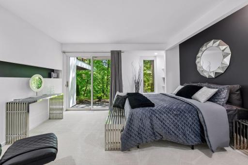 The first lower-level Bedroom offers direct access to the backyard, with a distinctive feature wall and built-in shelving adding character and function.