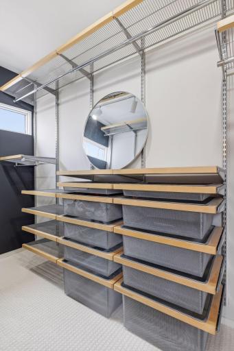 The Primary Walk-In Closet features a custom organizer system, providing a beautifully organized and highly functional space for effortless storage.