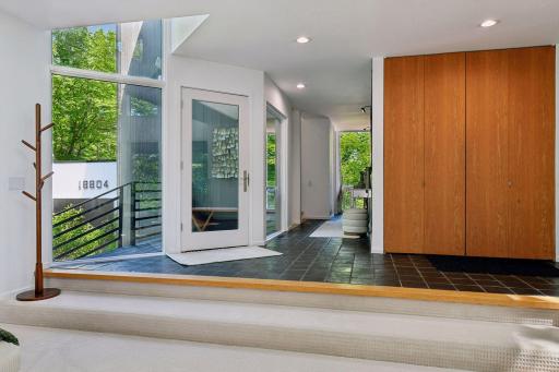 A light-filled foyer pairs sleek tiled floors with expansive windows and clean contemporary lines.