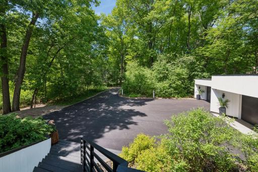 A canopy of mature trees creates remarkable privacy at the front of the home, with a secluded view down the driveway and no sight of the street beyond.