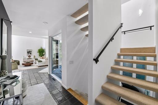 The main hallway creates a beautiful sense of connection, with the foyer and staircase opening toward the Great Room beyond.