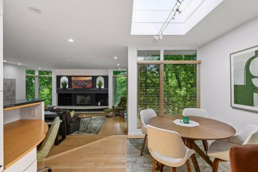 The Informal Dining Room features warm hardwood floors, a skylight overhead, and a custom built-in planning desk that adds both character and everyday functionality.