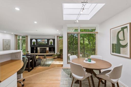 The Informal Dining Room features warm hardwood floors, a skylight overhead, and a custom built-in planning desk that adds both character and everyday functionality.