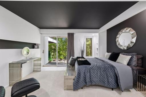 The first lower-level Bedroom offers direct access to the backyard, with a distinctive feature wall and built-in shelving adding character and function.