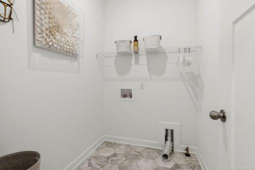 (Photo of a decorated model, actual homes finishes will vary) Main level laundry.
