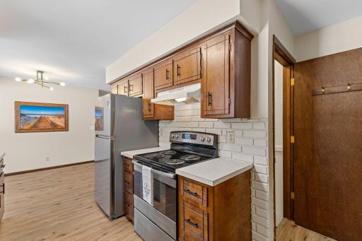 The galley style kitchen offers rich wooden cabinetry with a charming brick backsplash.