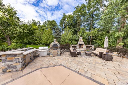 The outdoor kitchen is phenomenal, featuring a sink, fridge, grill, pizza oven, and tons of storage and countertop space