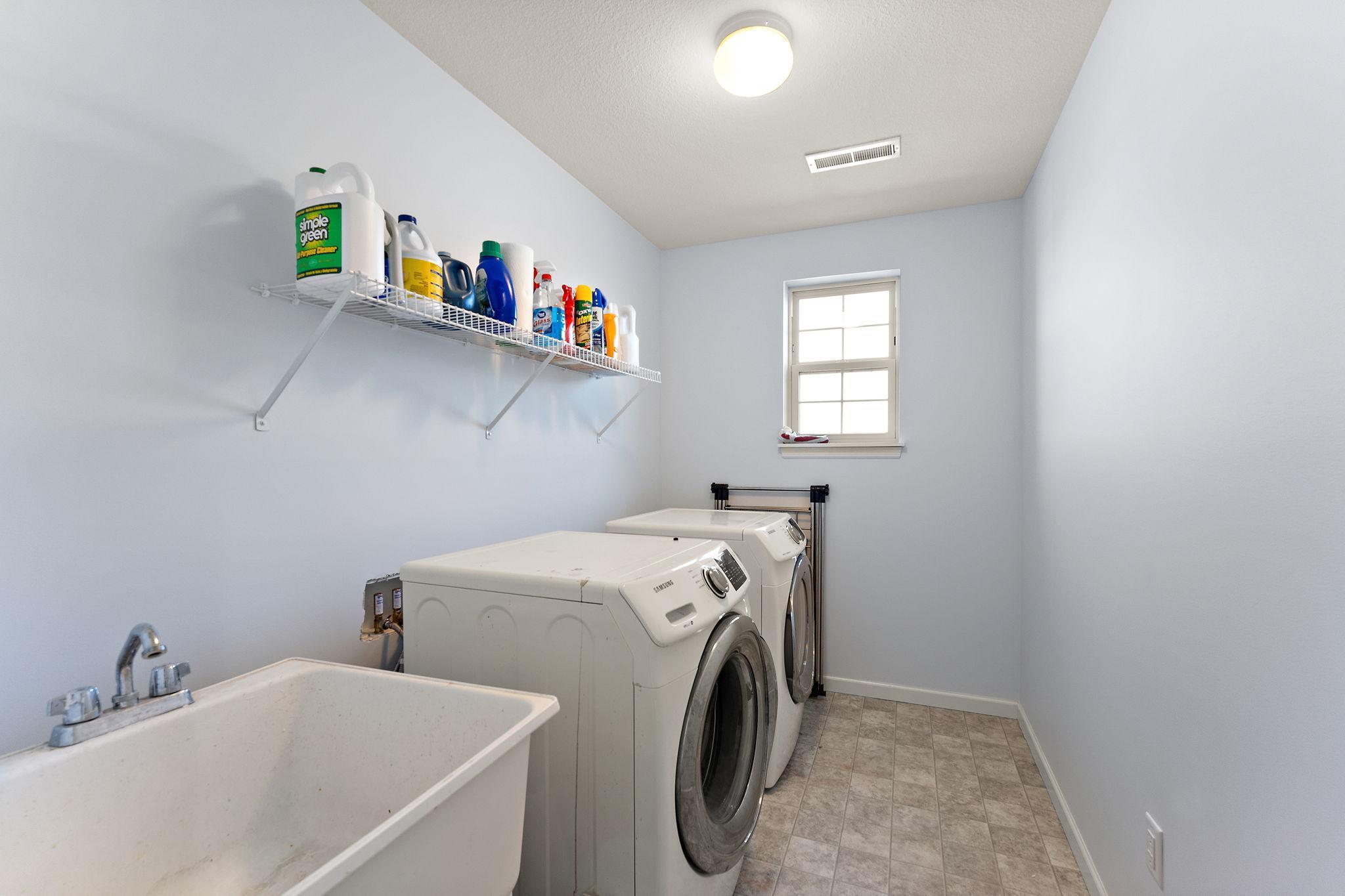 Conveniently located second-floor laundry room eliminates carrying baskets up and down stairs. Features built-in shelving for easy organization.