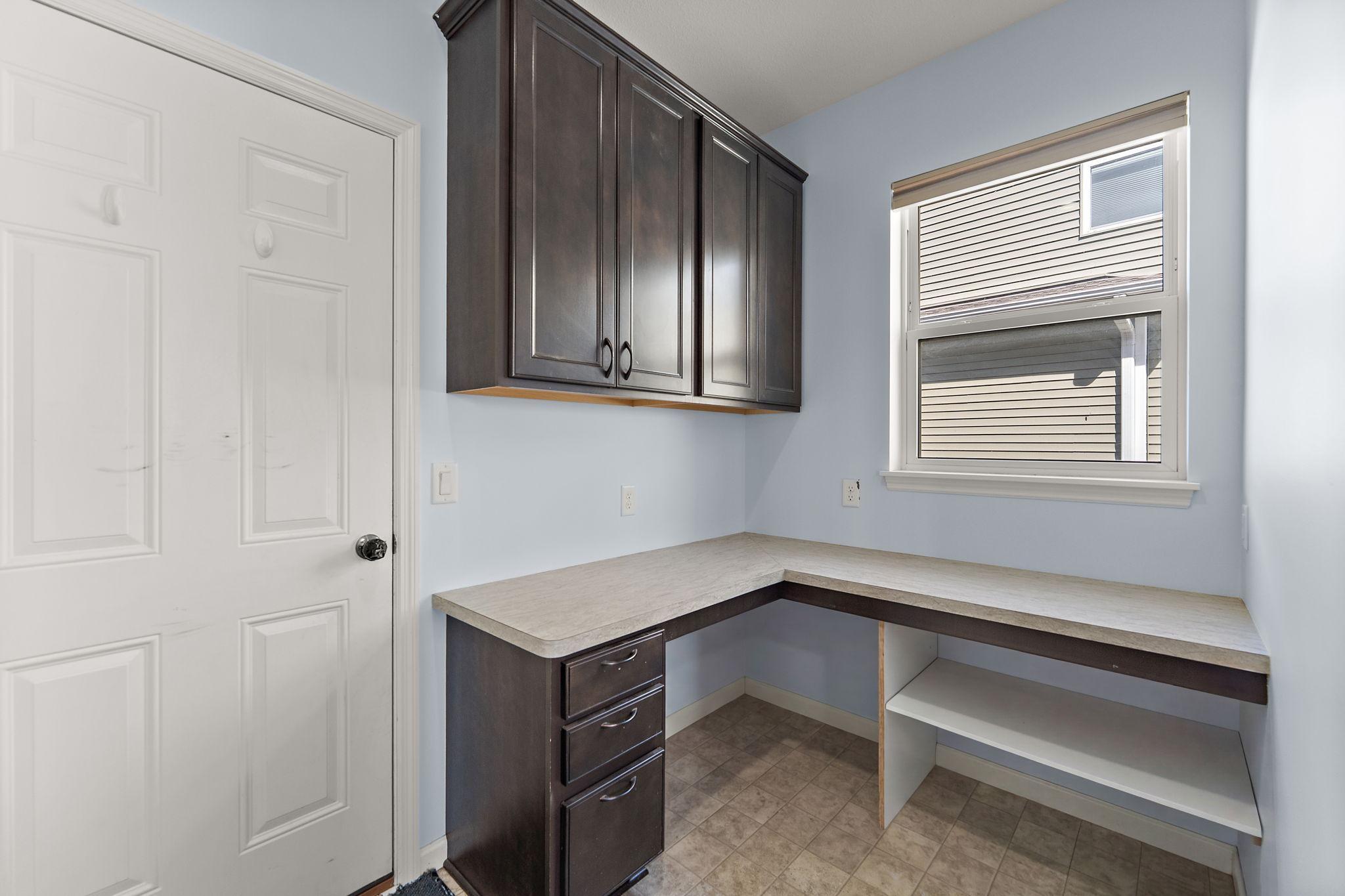 This clever mudroom area has been enhanced with a custom built-in workspace, perfect for a secondary home office, study nook, or a command center for the household.