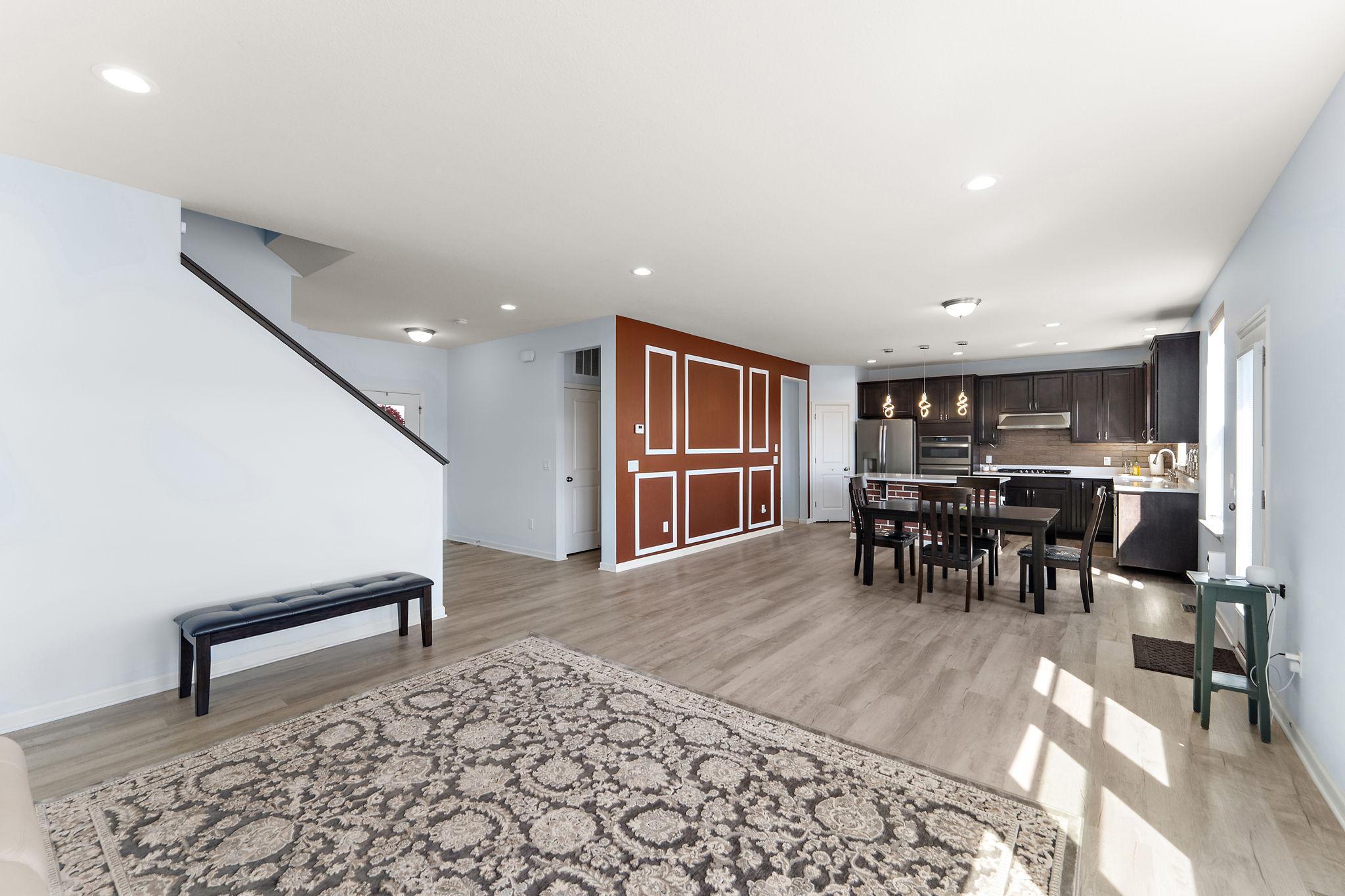 The entry transition highlights the thoughtful open-concept layout, featuring a striking designer accent wall and easy access to the upper level.