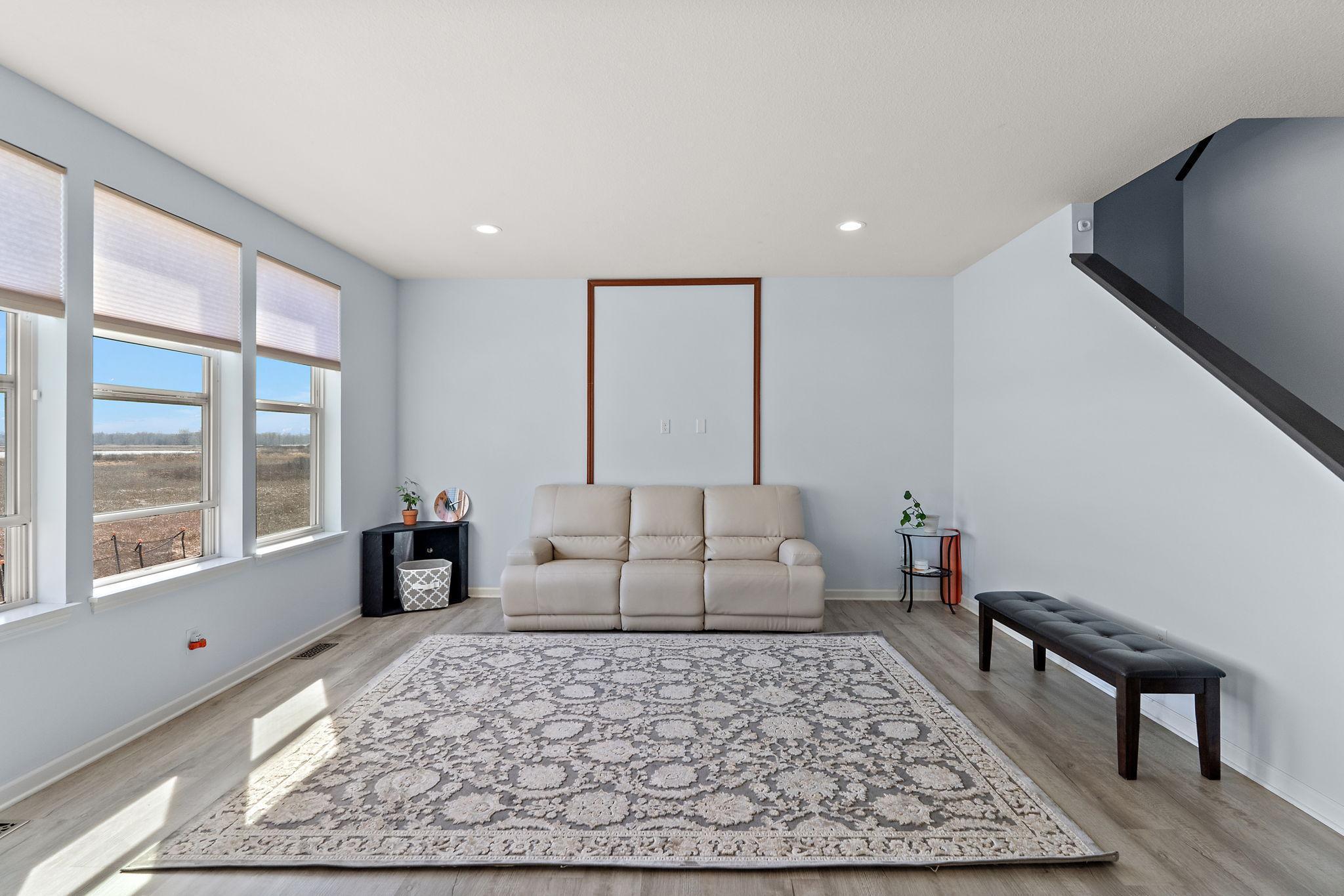 The sun-drenched living space is framed by large windows offering peaceful views of the protected nature preserve.