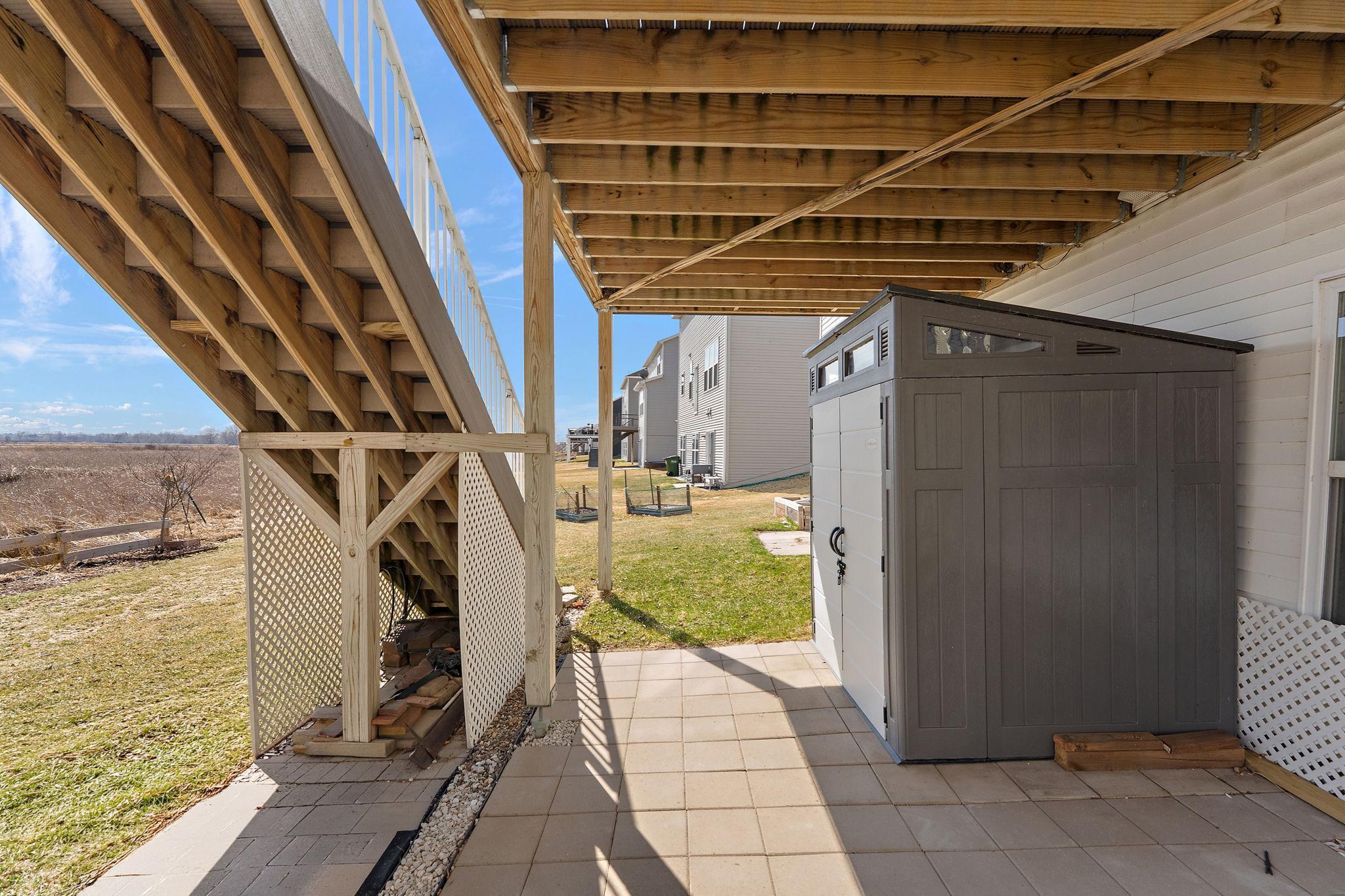 A versatile outdoor space featuring a walkout patio area and integrated storage shed, perfectly positioned to enjoy the chemical-free lawn and serene wetland views.