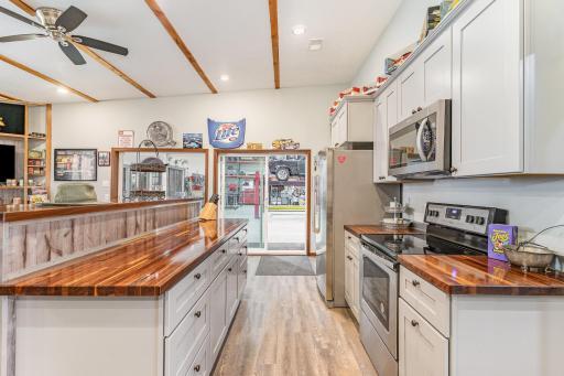 Entertaining space in shop full kitchen with butcher block countertops and SS appliances